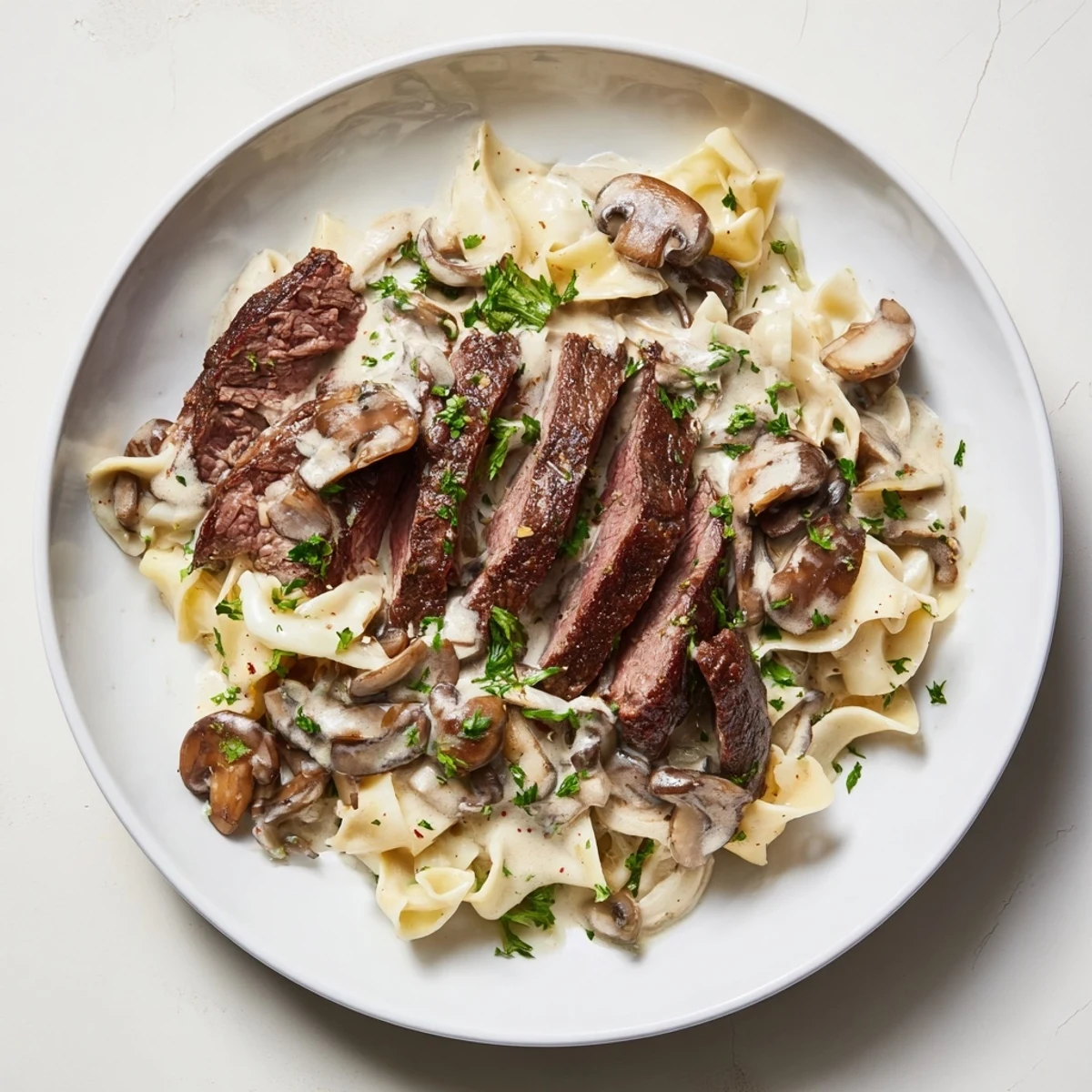 Tender beef and mushroom stroganoff with a creamy sour cream sauce, served atop fluffy egg noodles.