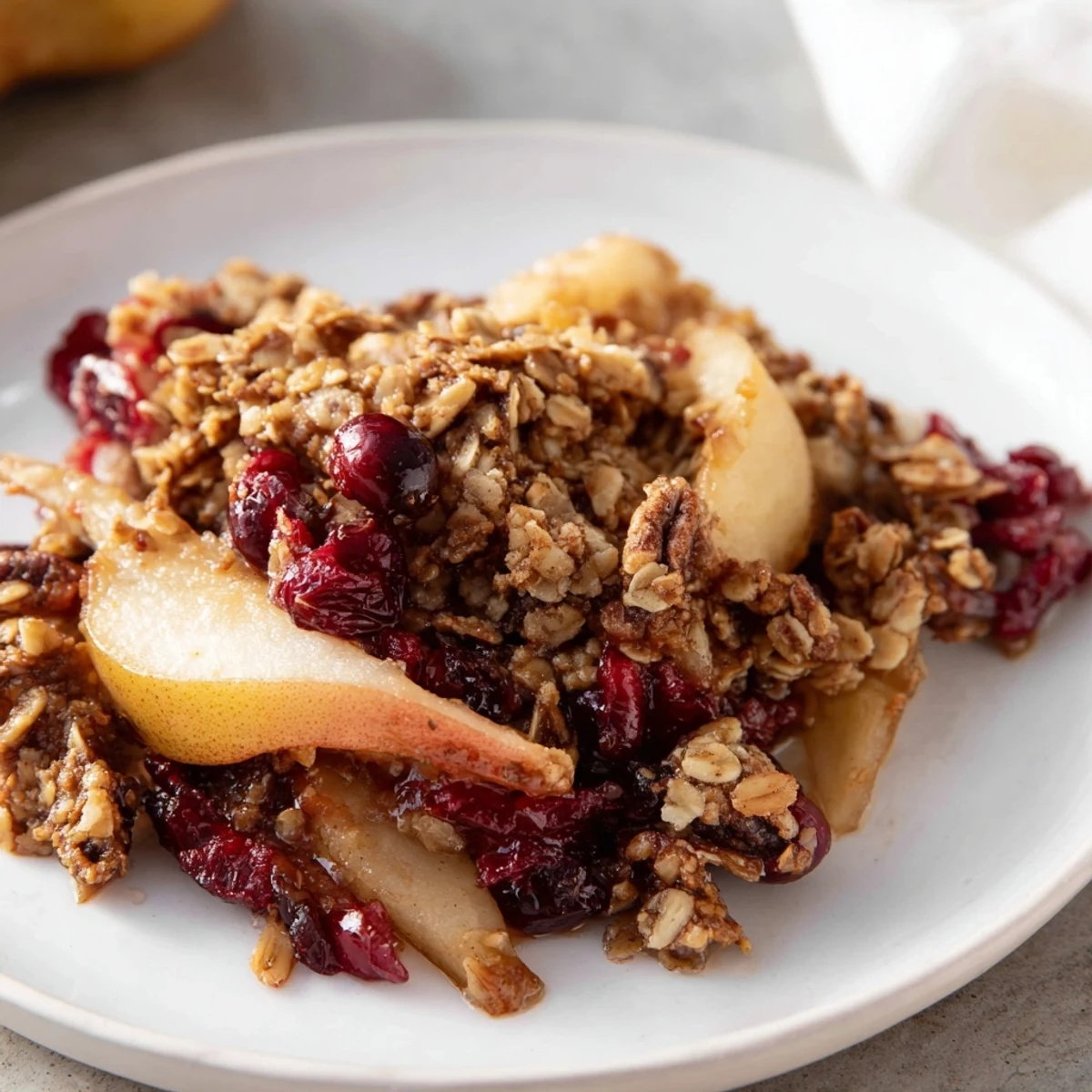 Warm Spiced Pear and Cranberry Crisp, a golden baked dessert bubbling with juicy fruit under a buttery oat topping.