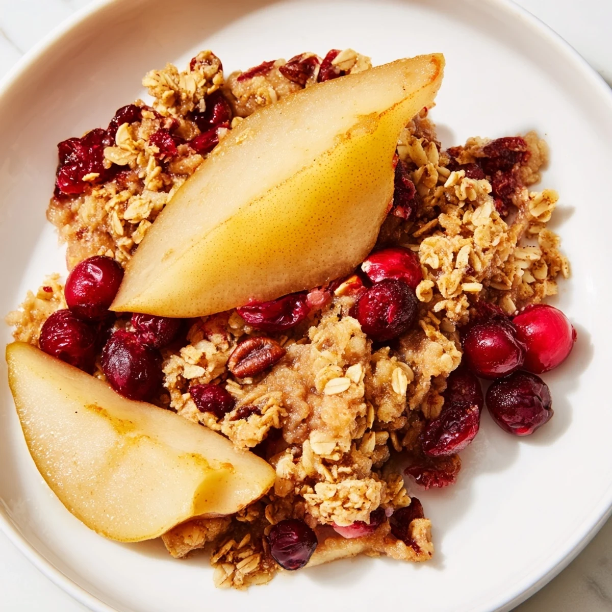 View a close-up of a Spiced Pear and Cranberry Crisp served hot, with steam rising from the delicious fruit filling.