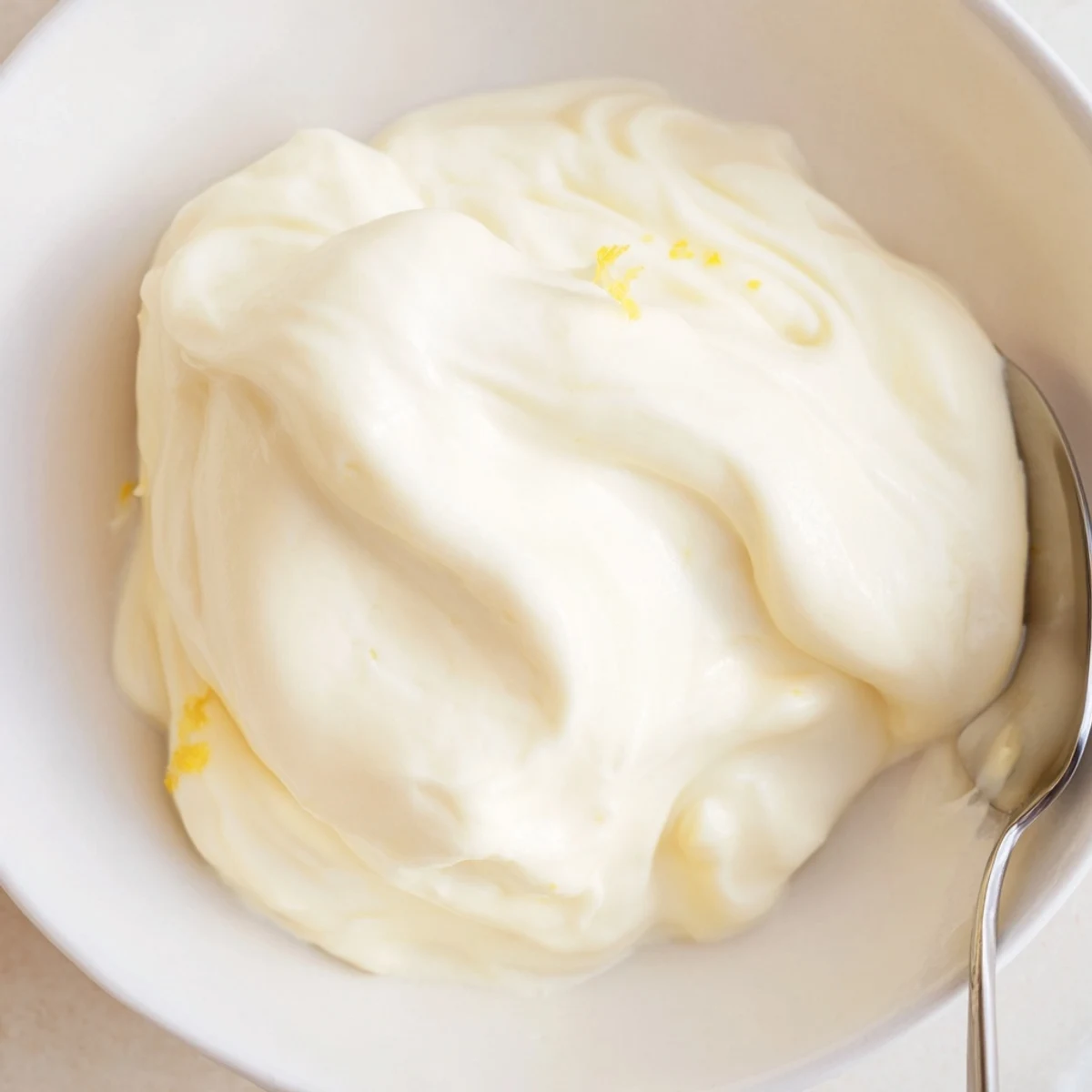 A spoonful of creamy sweet filling, ready to be layered into a delicate cake.