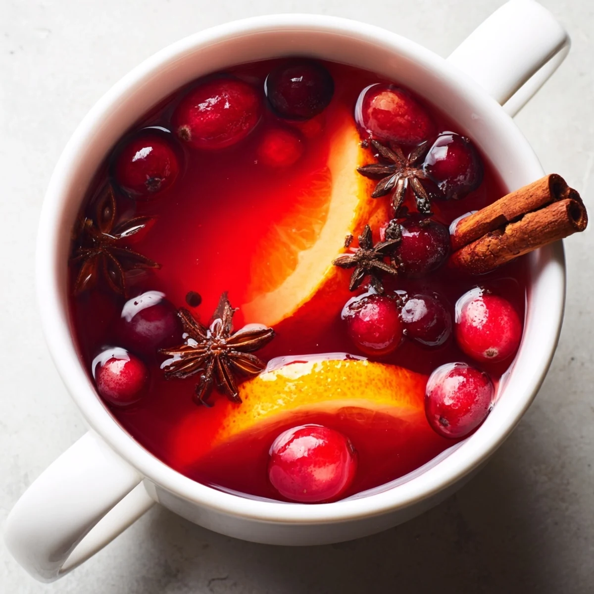 A warm mug of Cranberry Hot Tea, a festive beverage with bright red hues and spiced aromas.