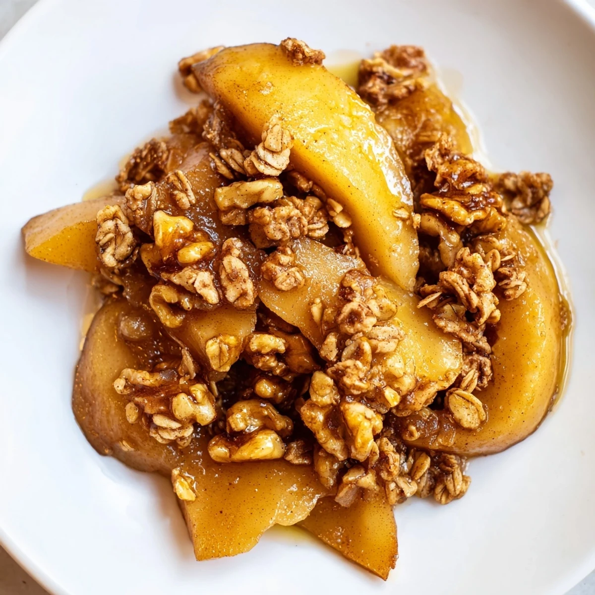 A close-up of a warm, spiced Pear Crisp with a perfectly browned oat crumble topping.
