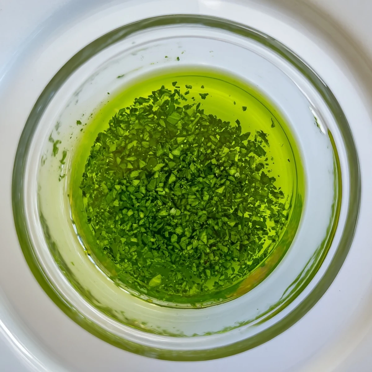 Vibrant green Mint Oil swirling in a glass jar, a fresh and flavorful condiment.