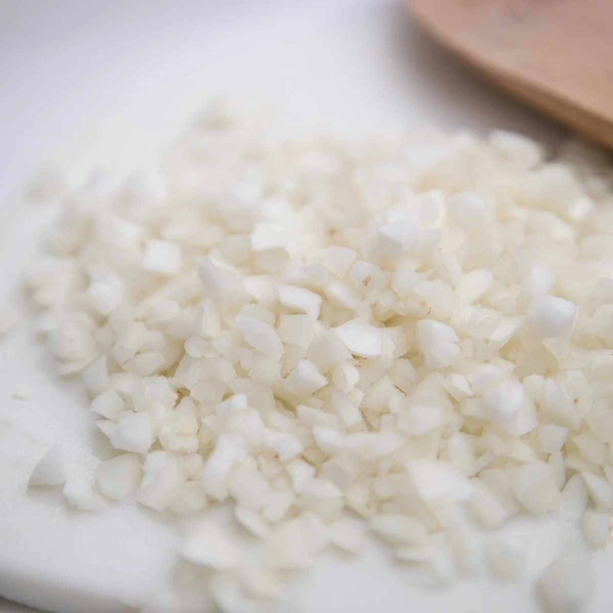 Fresh garlic cloves prepared for easy use, with a gleaming cutting board in sight.