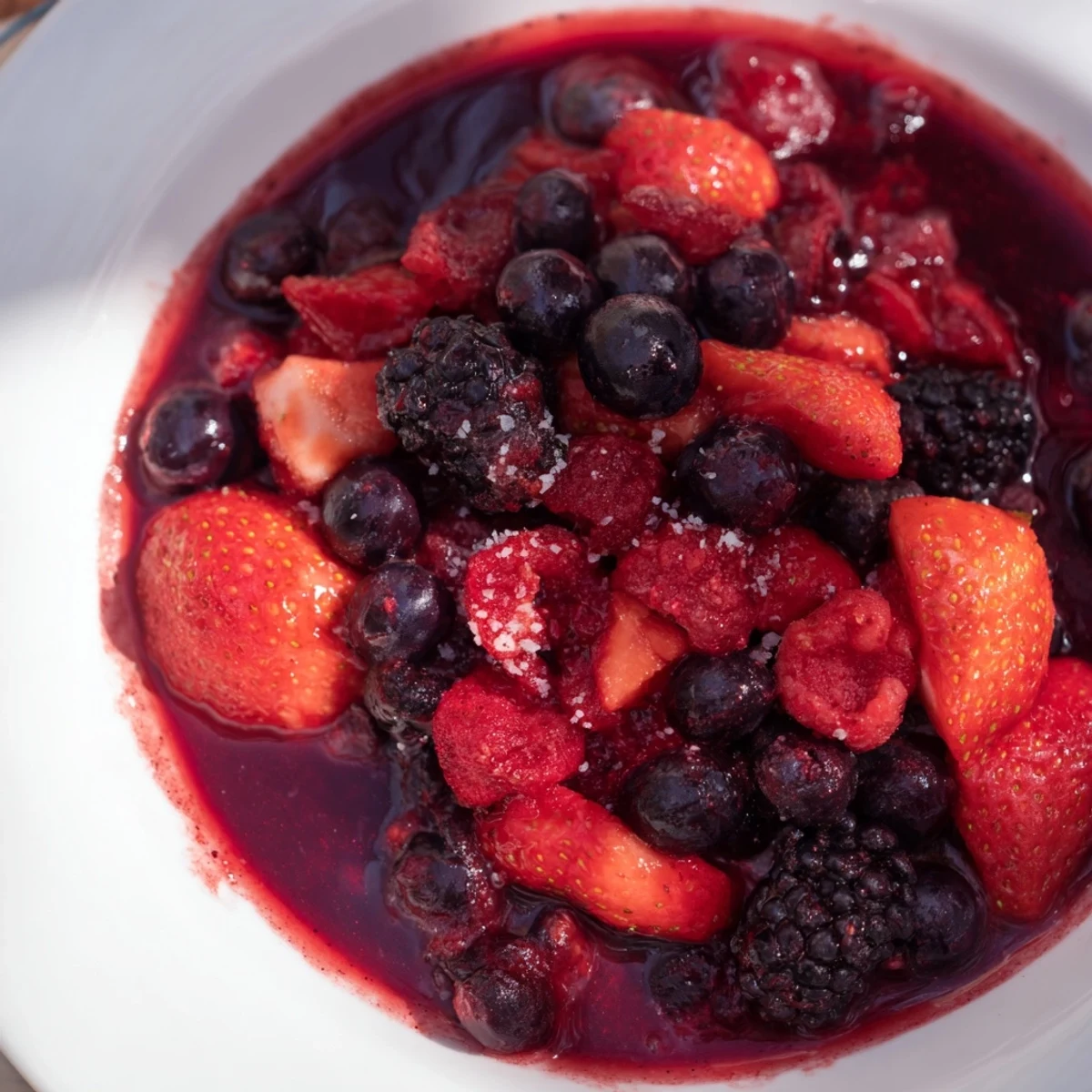 A warm berry compote with juicy berries, bursting with flavor, ready to drizzle over dessert.