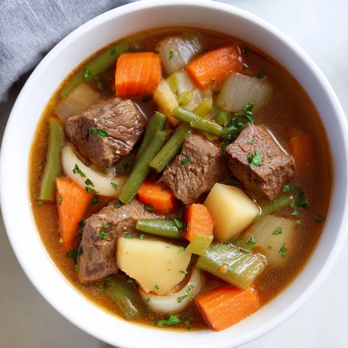 Spoonful of Beef Vegetable Soup with Potatoes, showcasing tender beef and soft potatoes.