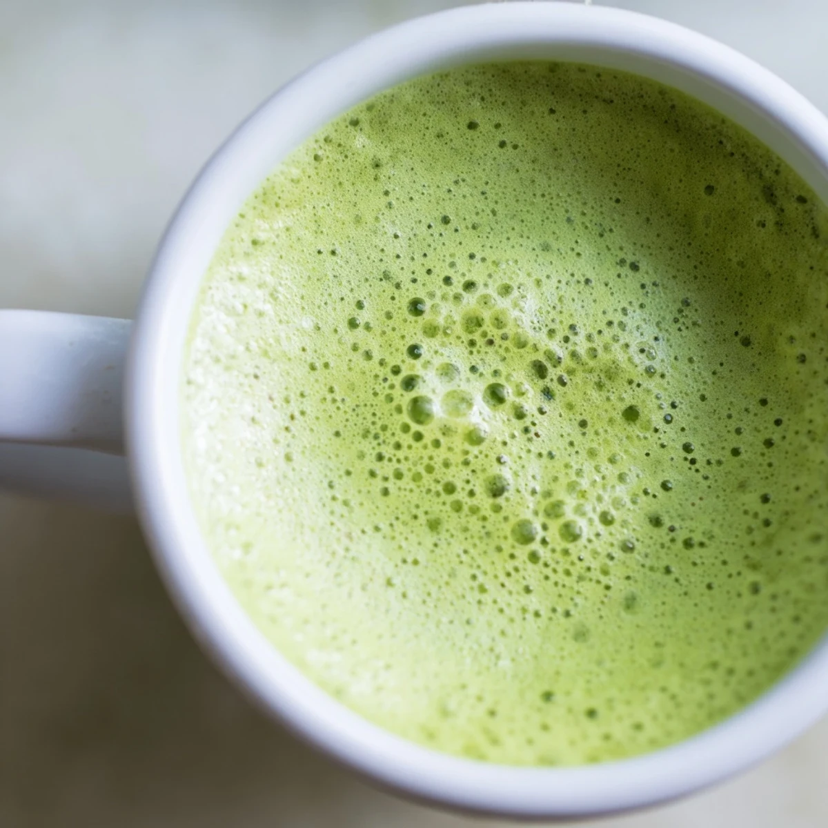 A freshly prepared vegan matcha latte with almond milk, showcasing the earthy green tea powder whisked into silky, steaming milk for a calming ritual.  
