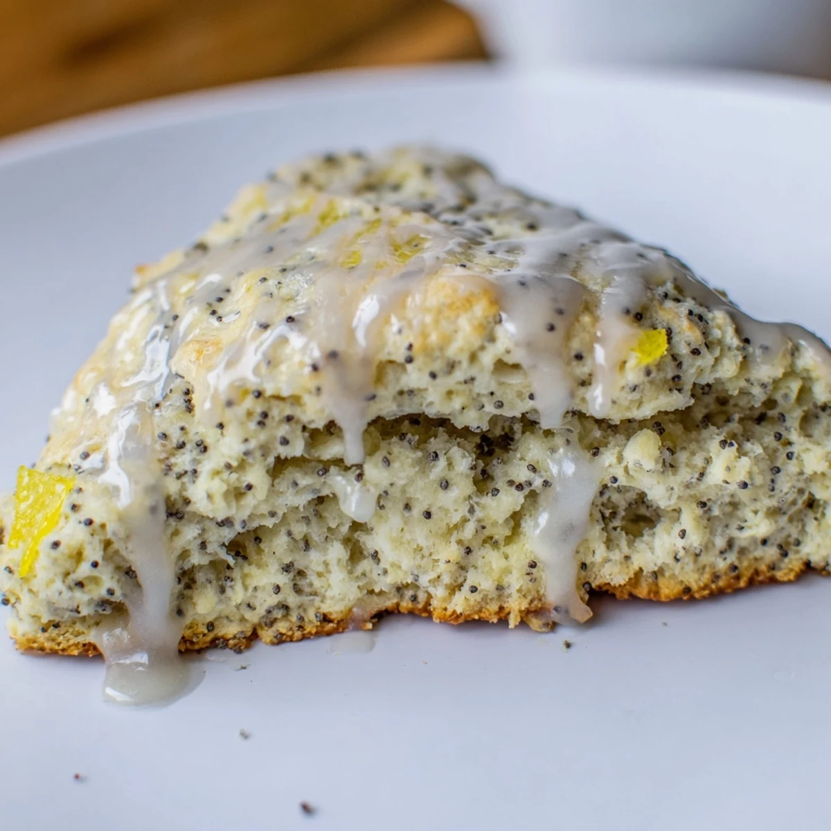 Freshly baked Lemon Poppy Seed Scones with a buttery crumb and bright citrus zest on a cooling rack.