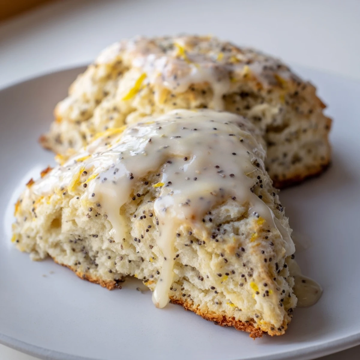 Tender, flaky Lemon Poppy Seed Scones stacked beside a cup of tea for a cozy afternoon snack.