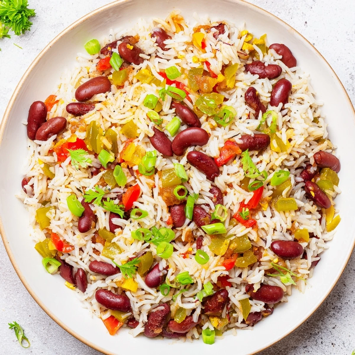 Mardi Gras rice and beans simmered in a pot, showing red peppers, celery, and kidney beans in Creole spices.