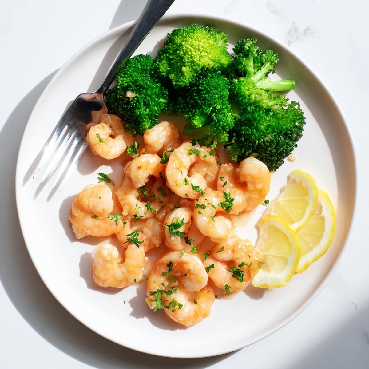 Quick Honey Garlic Butter Shrimp and Broccoli ready to eat, garnished with fresh parsley and a sprinkle of red pepper flakes.
