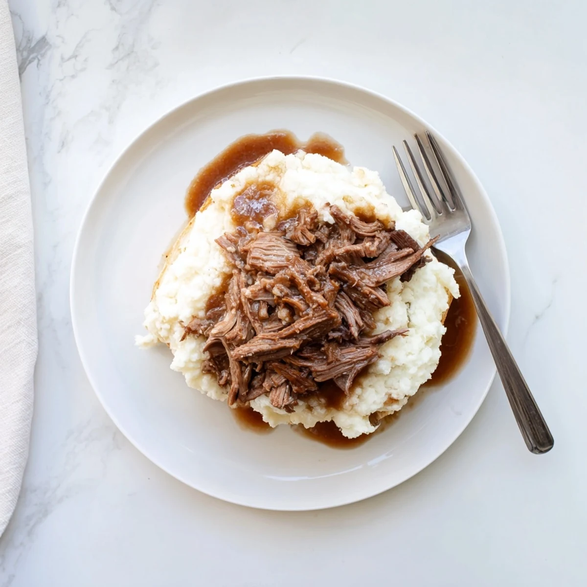Hearty Slow Cooker Beef Manhattan served steaming hot with mashed potatoes and brown gravy, perfect for chilly nights.