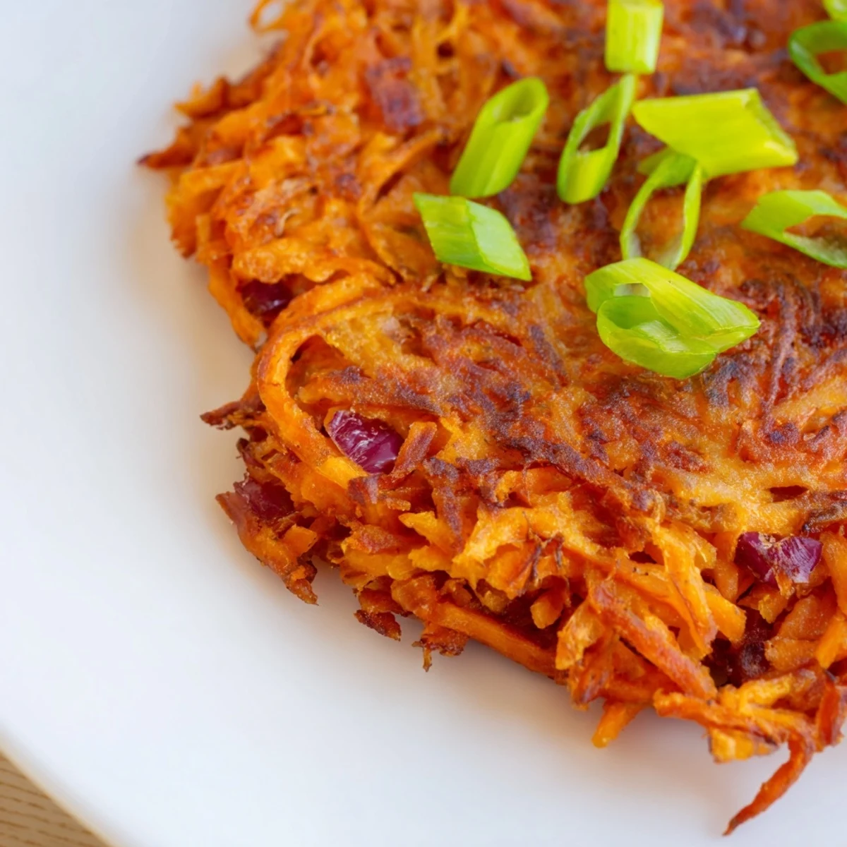 Golden baked Healthy Sweet Potato Hash Browns patties are crispy on the edges and tender in the center on a parchment-lined tray.