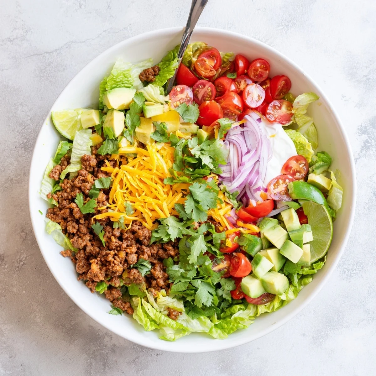 Healthy Low Carb Burrito Bowl featuring spiced meat, crunchy cucumbers, and cauliflower rice, served with salsa and fresh cilantro.