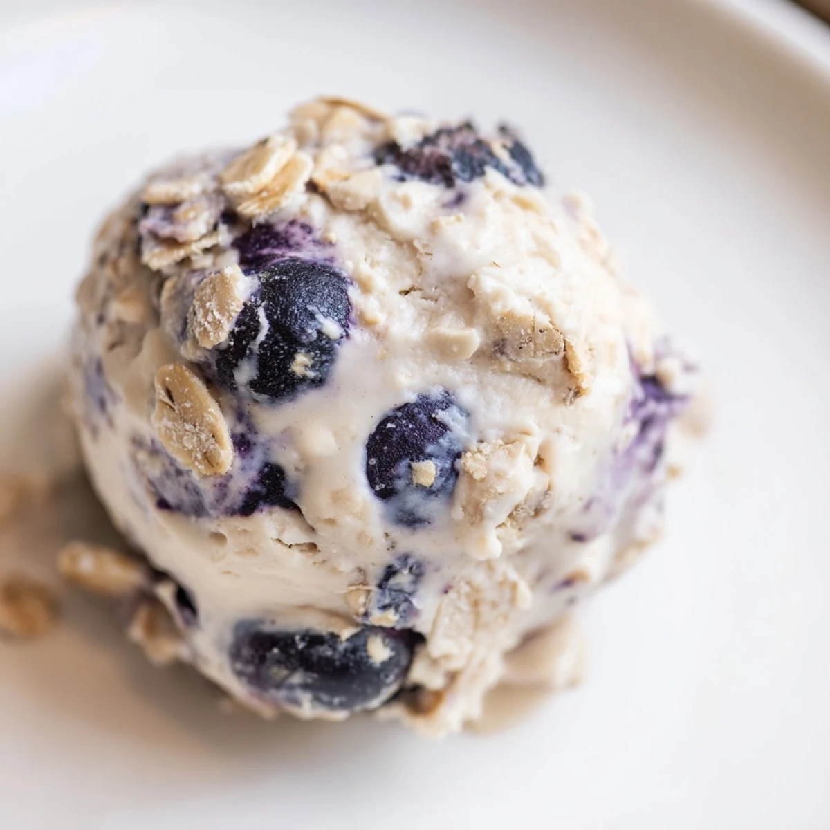 A close-up shows the creamy blueberry cheesecake protein bites rolled into balls, highlighting the texture from oats and almond flour.