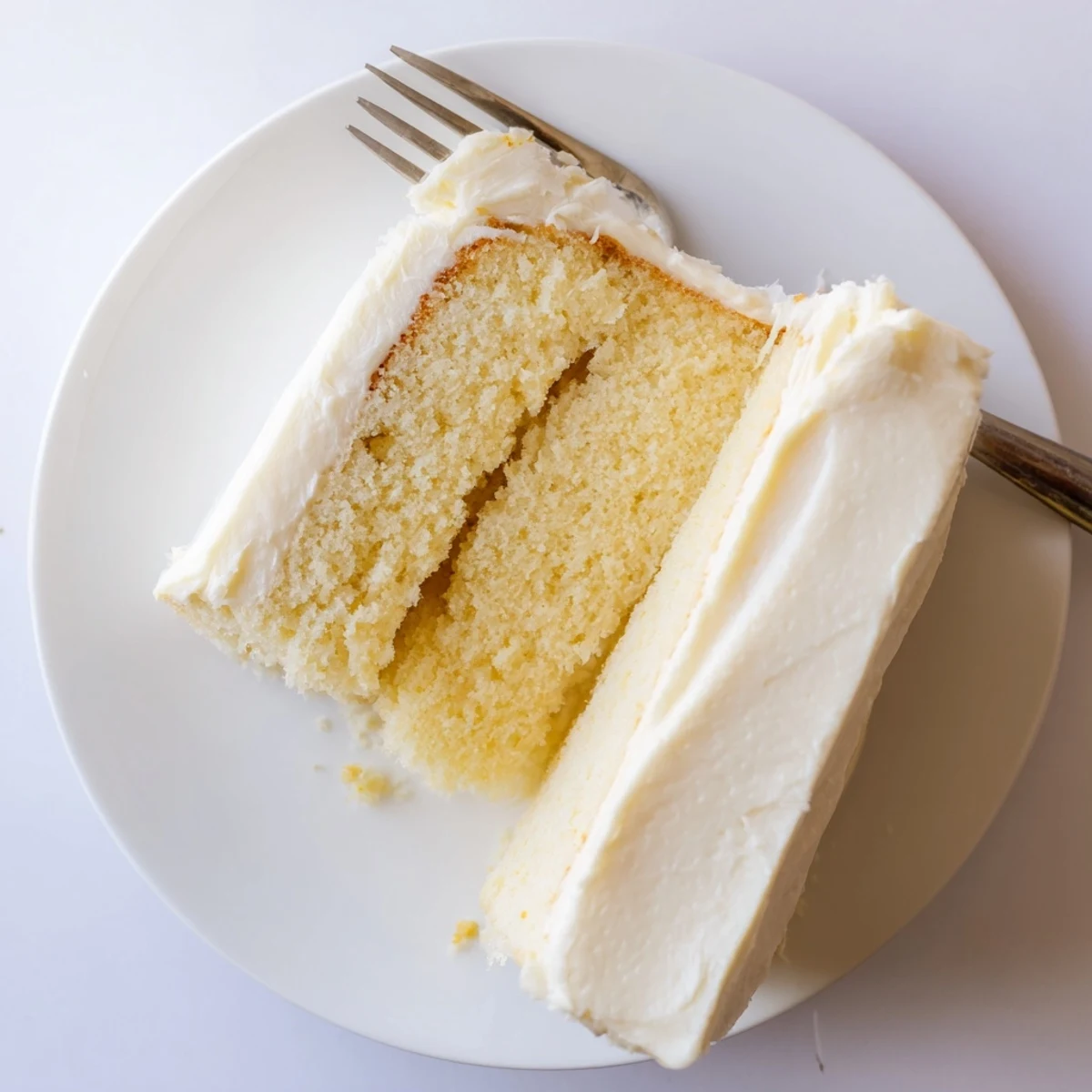 Freshly baked Perfect Vanilla Cake layers stacked high with vanilla buttercream frosting between them.