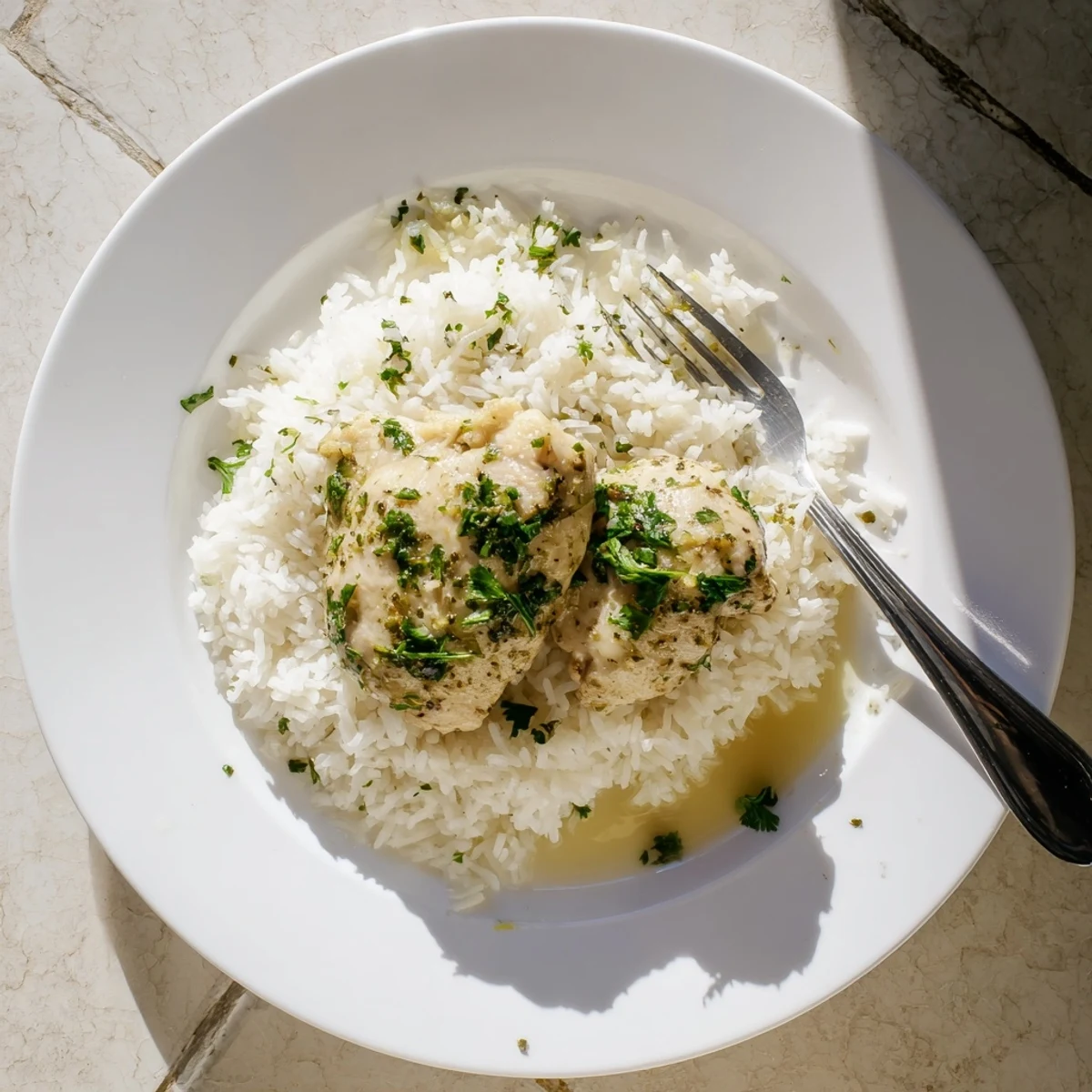 Juicy, tender chicken thighs slow-cooked with lemon and herbs, served over a bed of fluffy rice and drizzled with savory juices.  