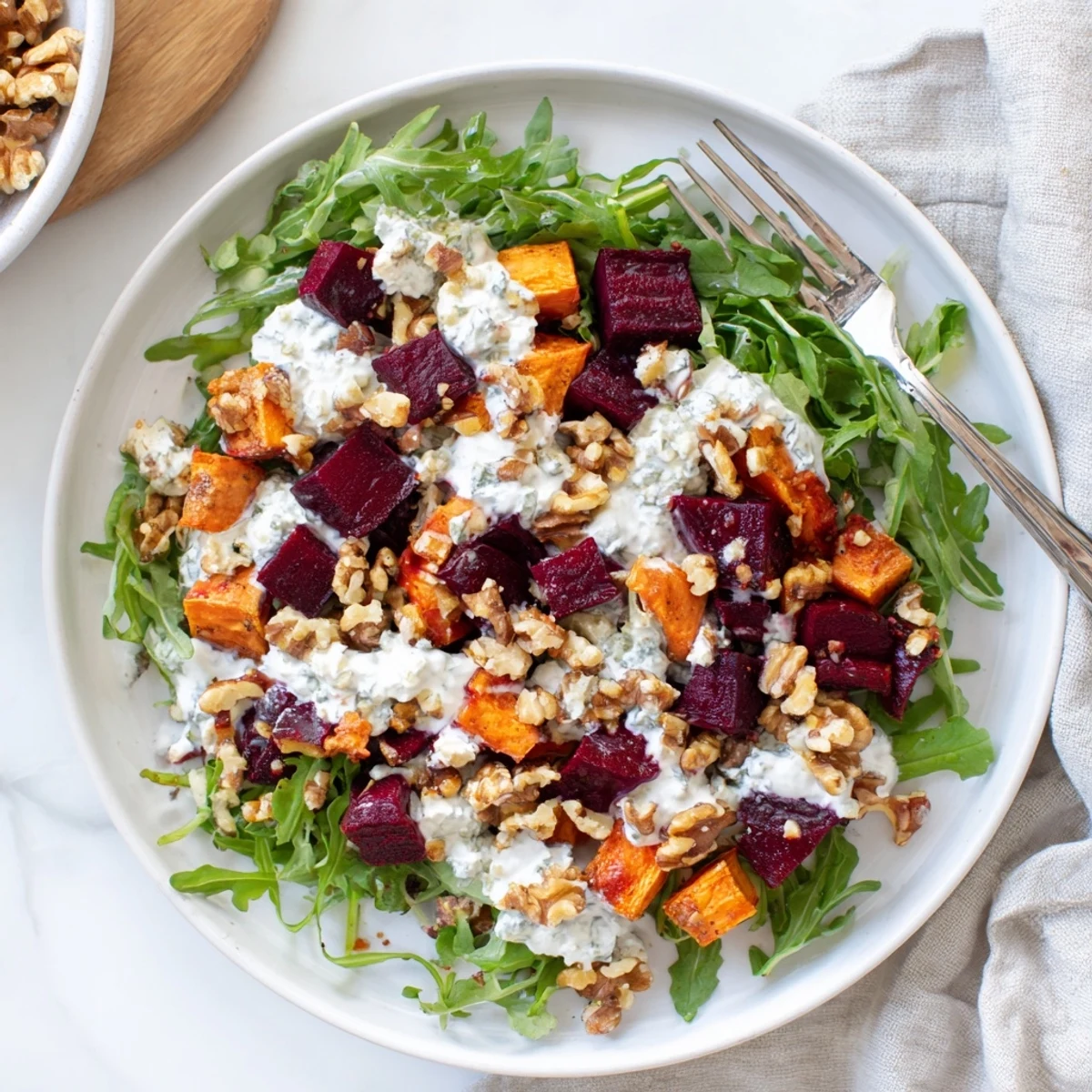 Vibrant vegetarian salad featuring roasted beets, sweet potato, walnuts, and luscious feta cheese crumbles