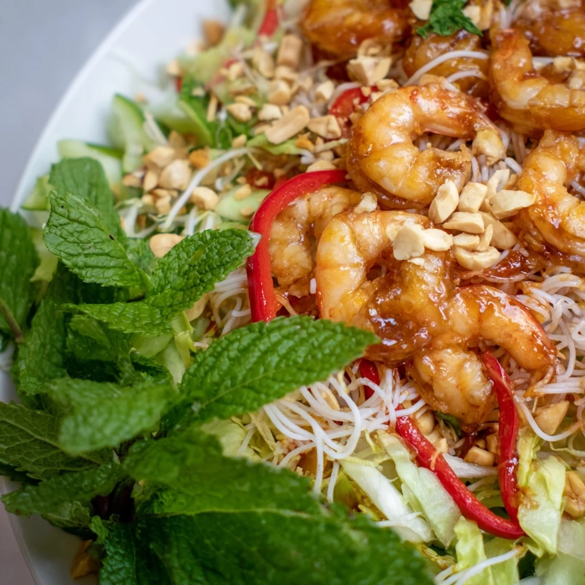 Colorful Spring Roll Salad with Spicy Ginger Dressing featuring crisp vegetables and plump shrimp in a bowl