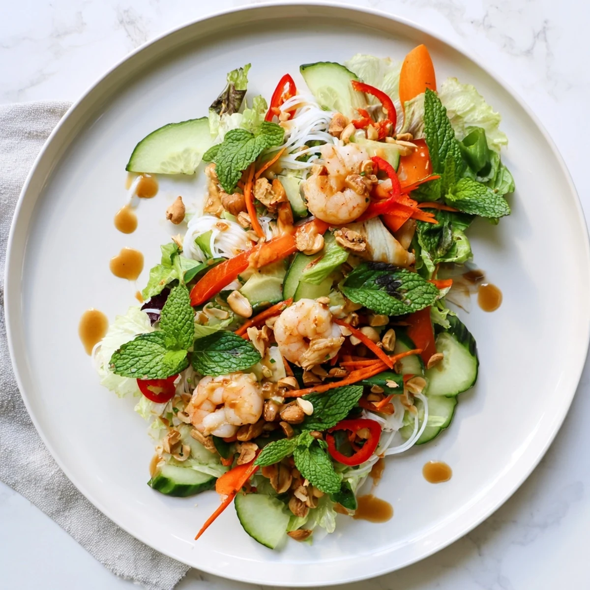 Vibrant spring roll salad featuring rice vermicelli, sliced bell pepper, fresh mint, cilantro, and spicy ginger dressing