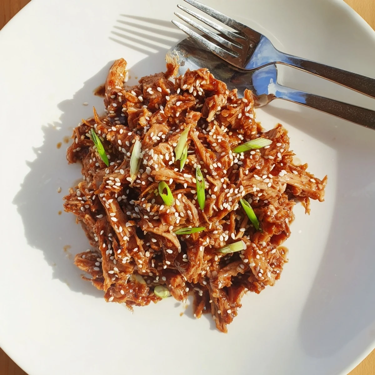 Tender slow cooker Sesame Chicken pieces coated in a savory sweet honey soy glaze over fluffy white rice