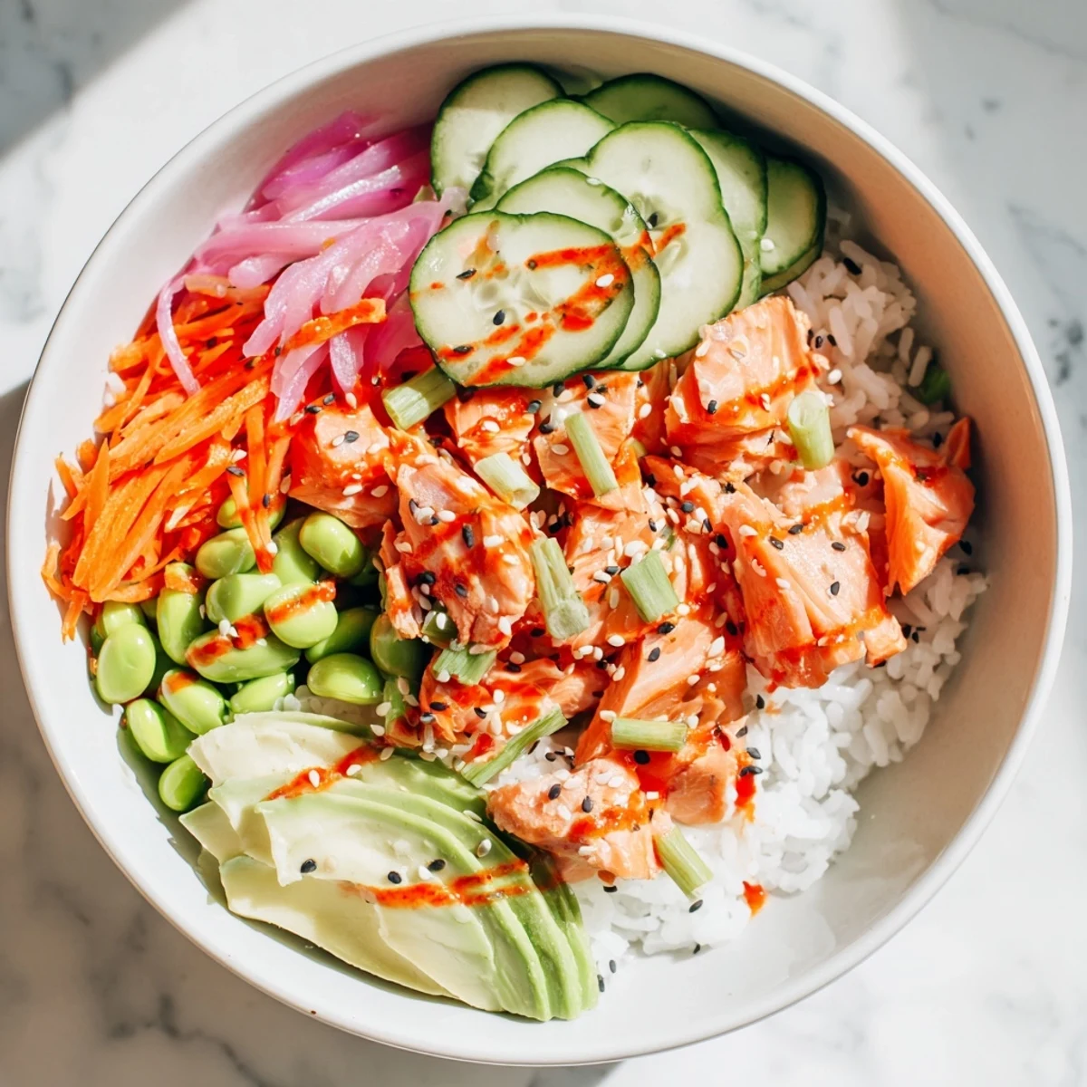 Tender baked salmon arranged over fluffy rice with crisp vegetables and zesty creamy sauce topping