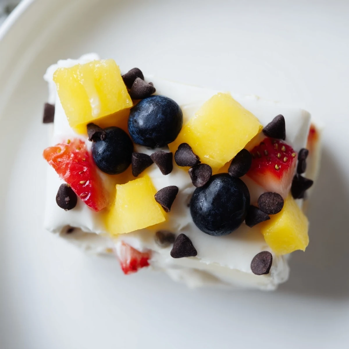 Creamy frozen Greek yogurt bites sprinkled with mini dark chocolate chips and chopped nuts ready for healthy snacking