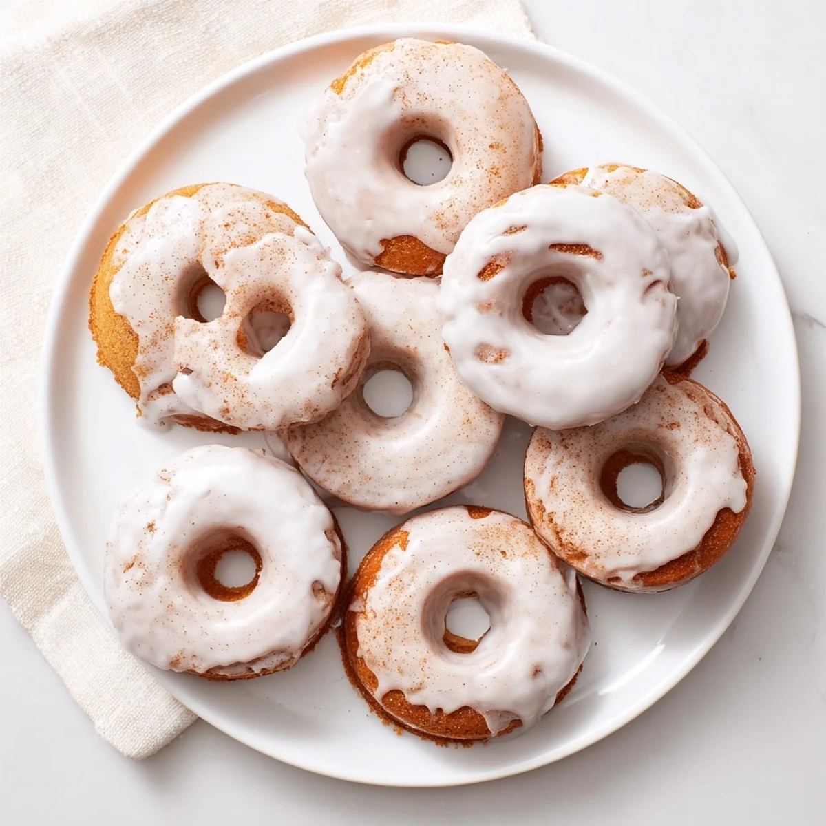 Light and fluffy Greek yogurt cake donuts topped with white icing and colorful sprinkles
