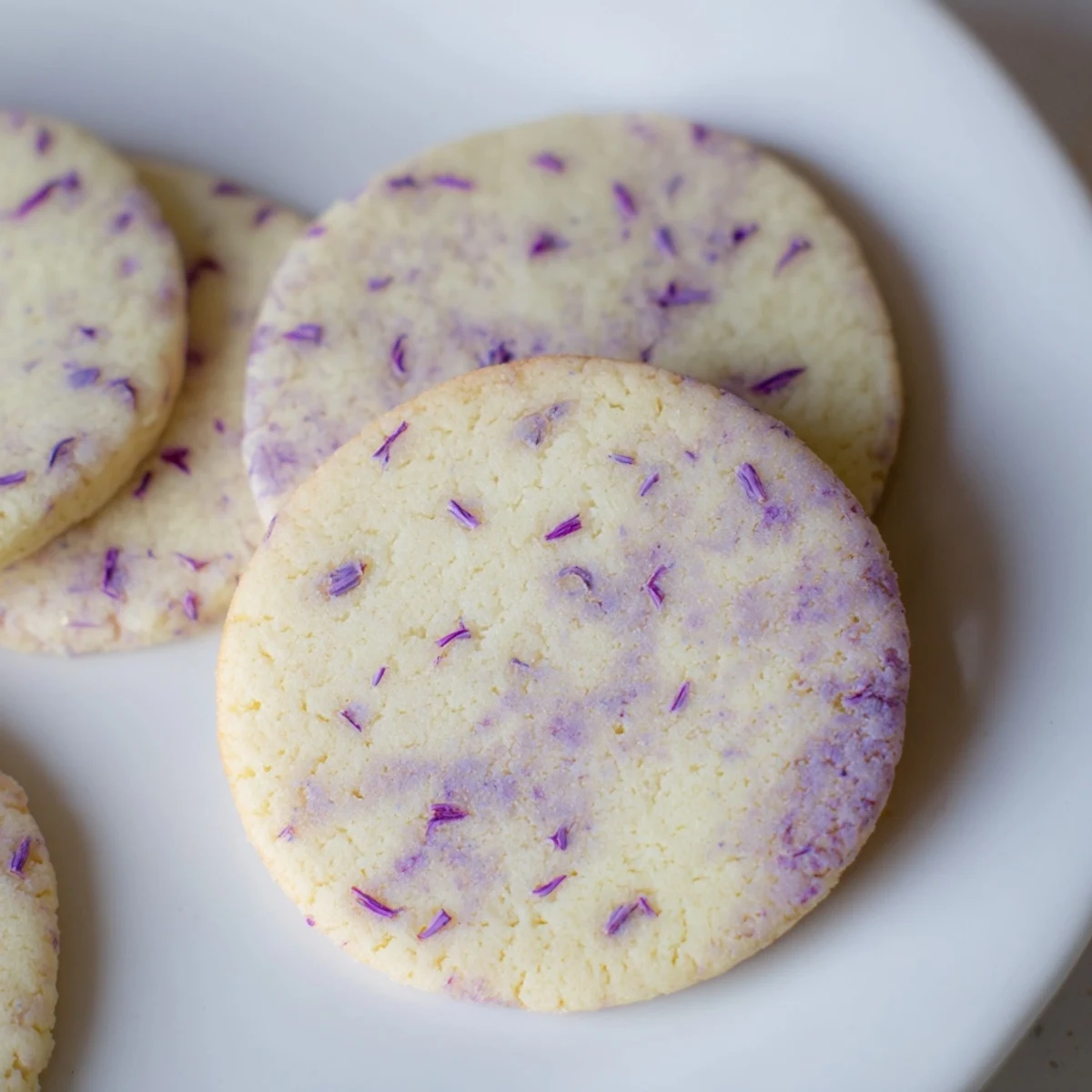 Buttery lilac sugar cookies cooling on wire rack with faint golden edges and floral fragrance