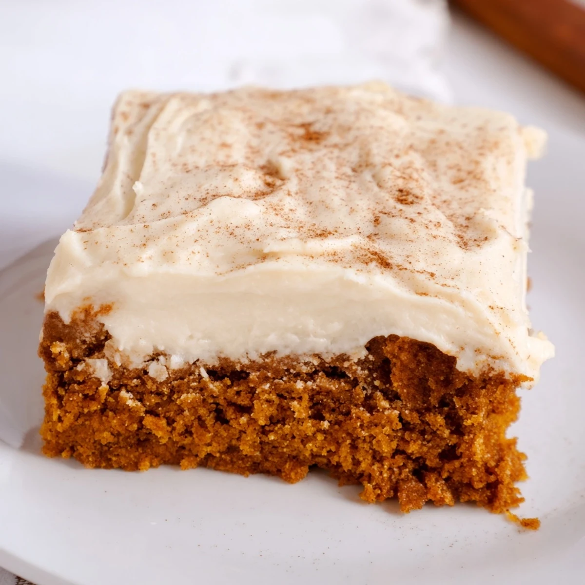 Spiced pumpkin bars with thick cream cheese frosting swirled atop a moist golden crumb