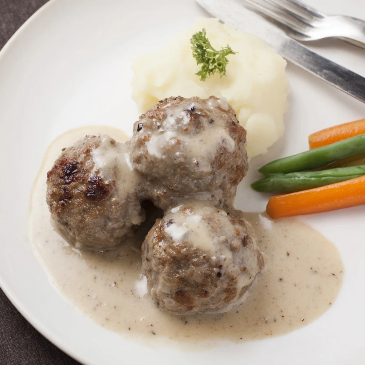 Close-up of golden-browned Homemade Ikea Meatballs sizzling in butter, fragrant with spices