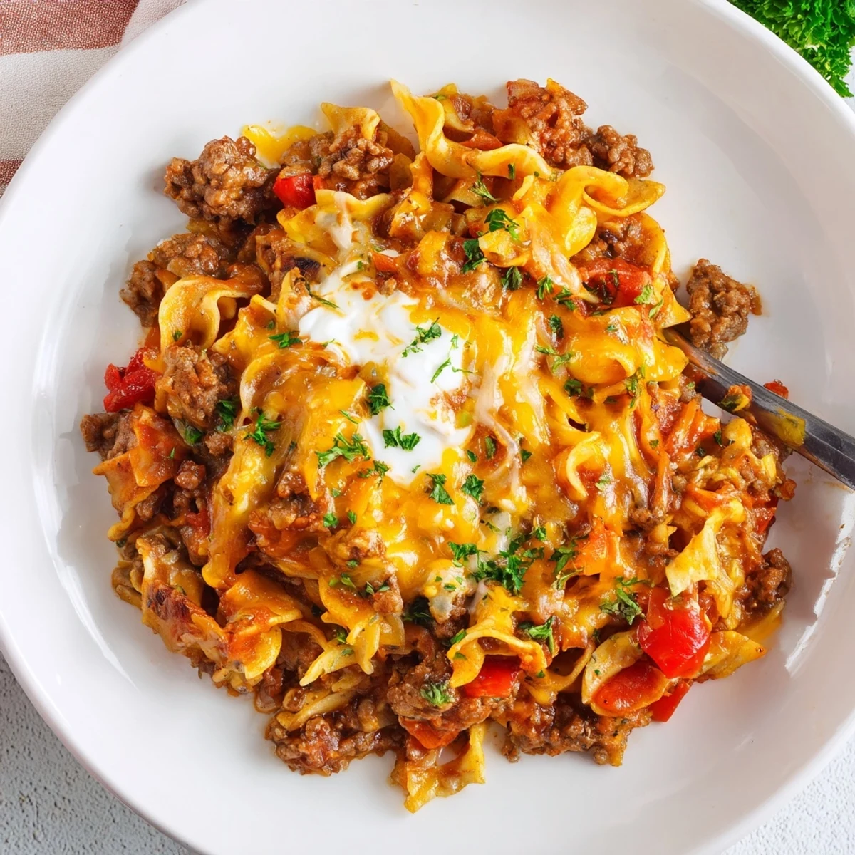 Spoonful of Beef Noodle Casserole revealing tender meat and saucy noodles.