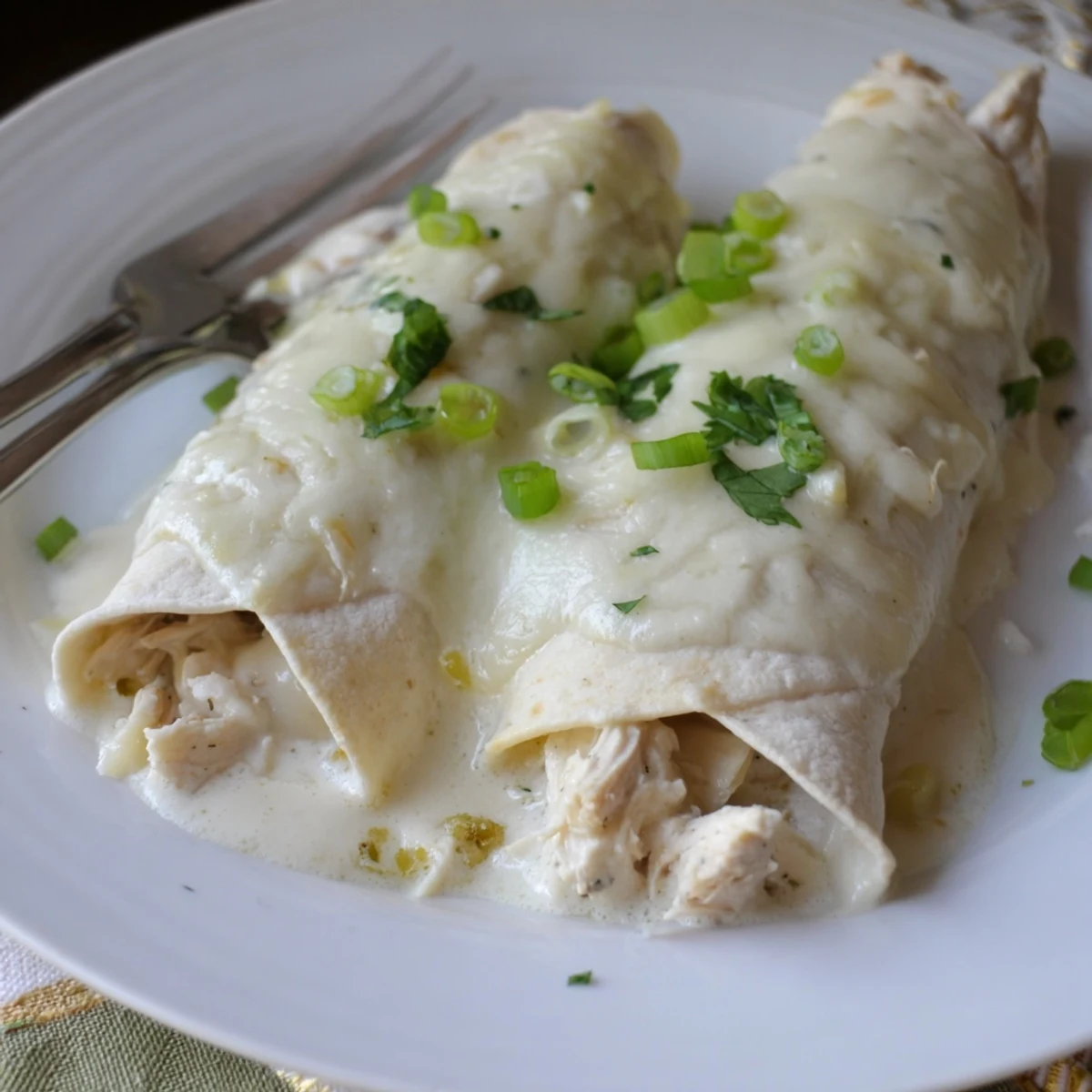 Sliced Creamy White Chicken Enchiladas on plate with Spanish rice and lime