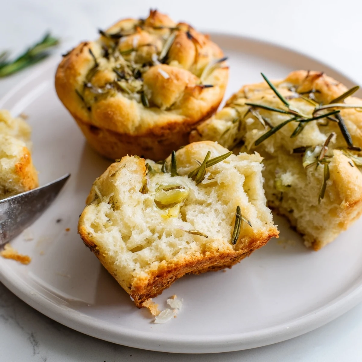 Golden Garlic Rosemary Focaccia Muffins brushed with olive oil, topped with flaky sea salt
