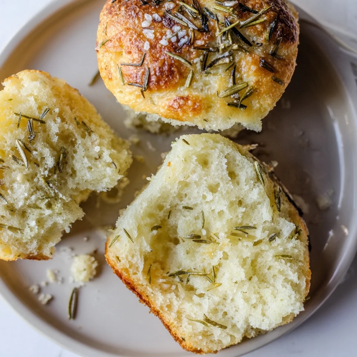 Soft, herby Garlic Rosemary Focaccia Muffins cooling on wire rack, savory aroma
