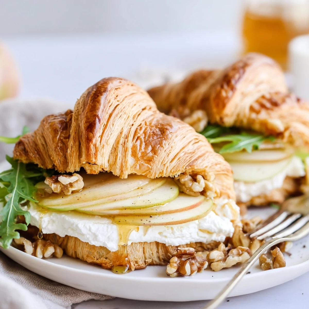 Brunch-ready Apple Goat Cheese Croissant Sandwich paired with sparkling white wine