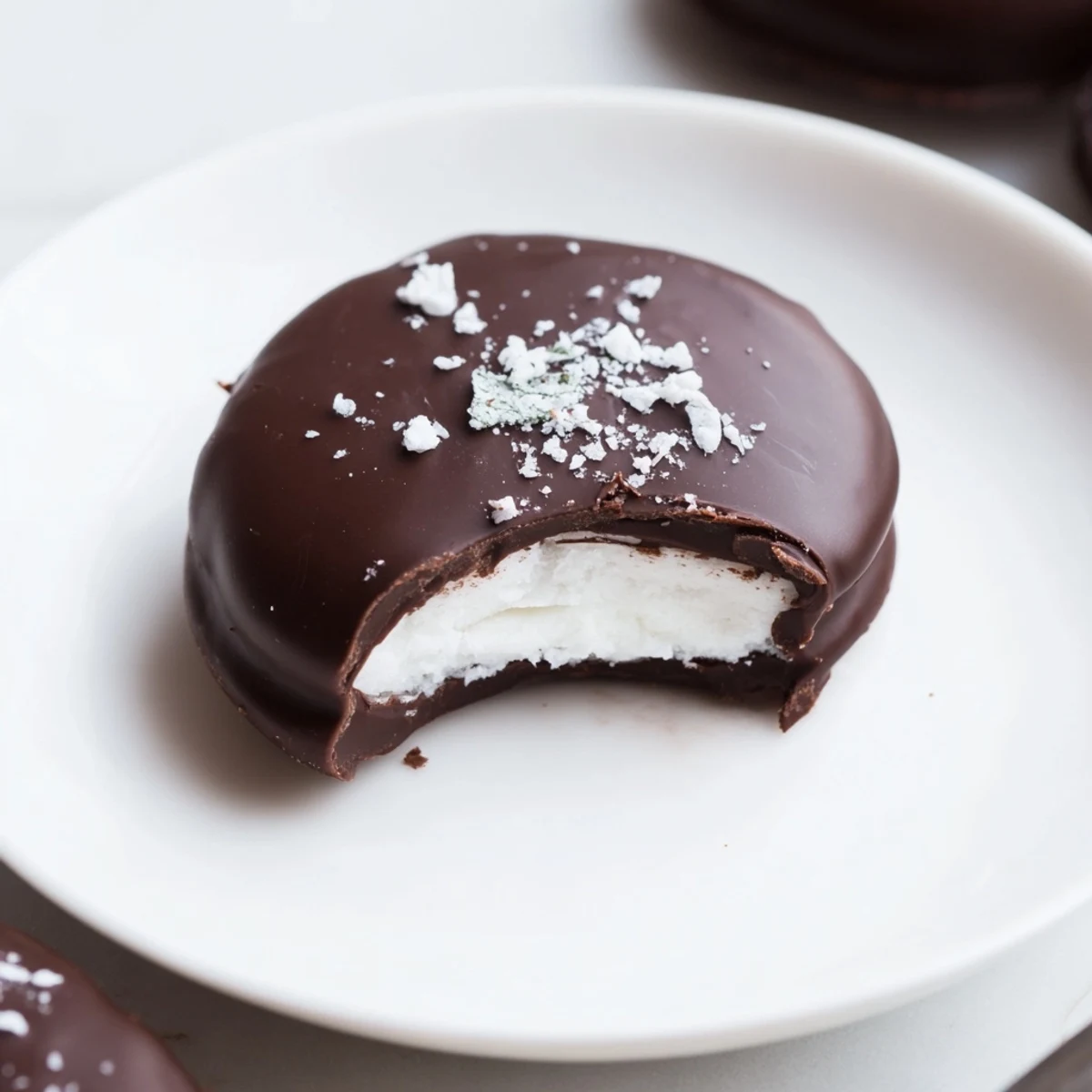 Peppermint Patties on parchment, glossy dark chocolate and snowy sugar centers